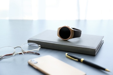 Photo of Composition with stylish smart watch on grey stone table