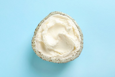 Bowl of tasty cream cheese on color background, top view