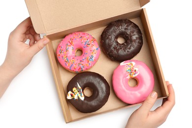 Photo of Woman with box of delicious donuts on white background, top view