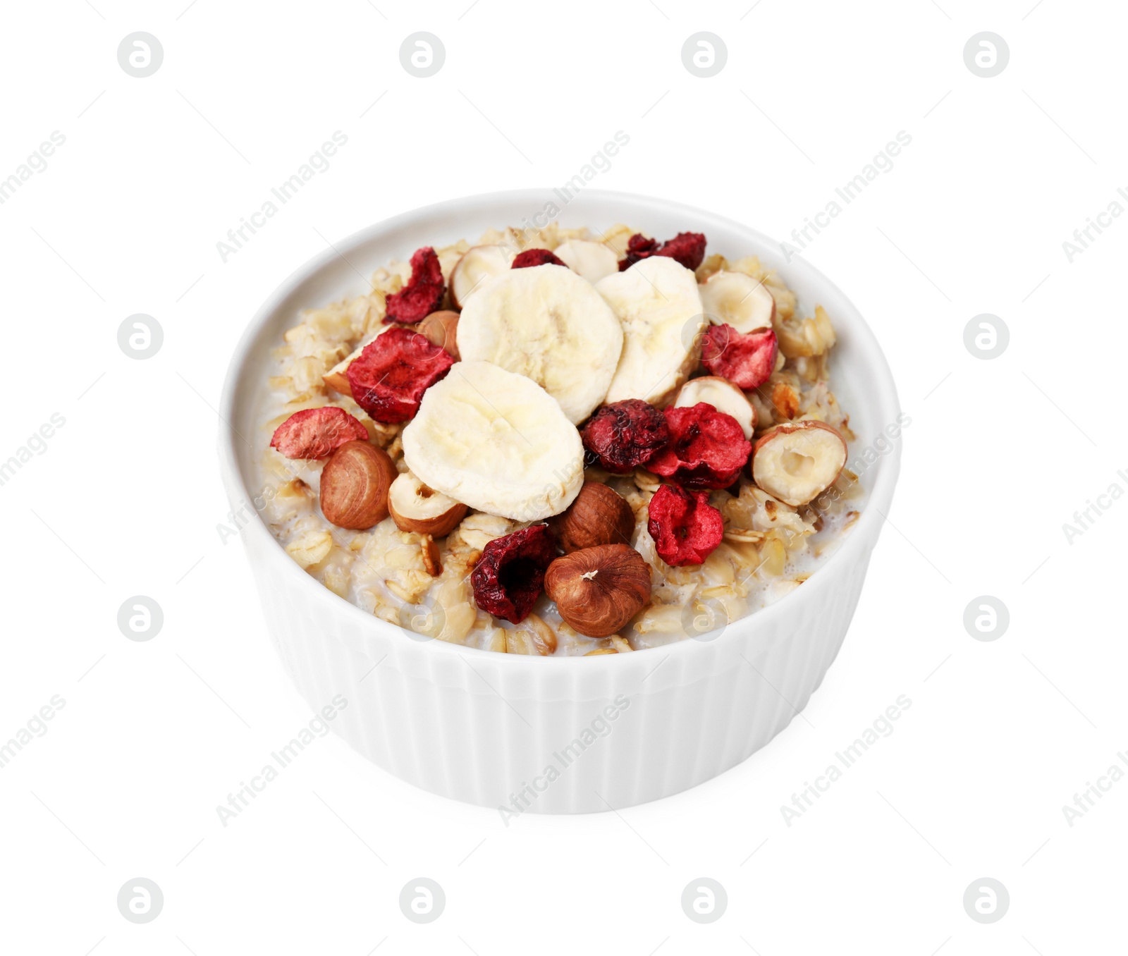 Photo of Delicious oatmeal with freeze dried berries, banana and hazelnuts isolated on white