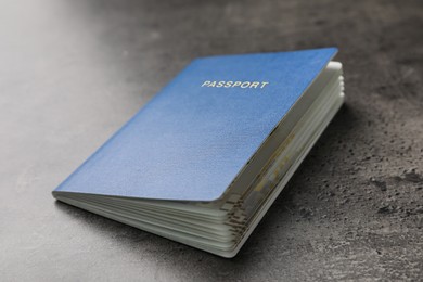 Photo of Blank blue passport on dark grey table, closeup