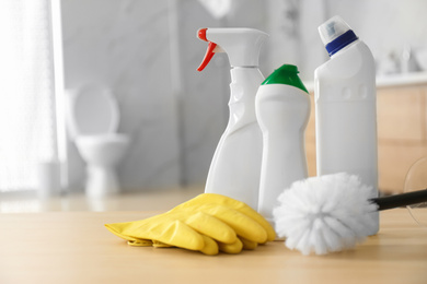 Photo of Cleaning supplies and toilet bowl in bathroom. Space for text