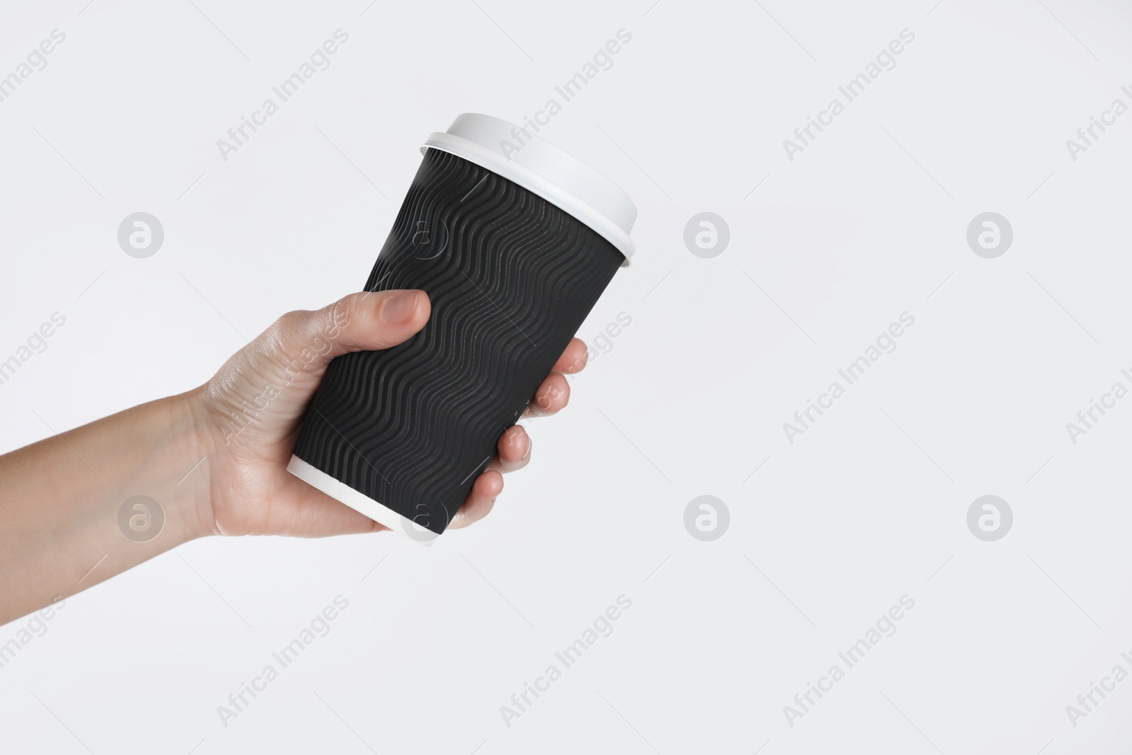 Photo of Woman holding takeaway paper coffee cup on white background, closeup. Space for text