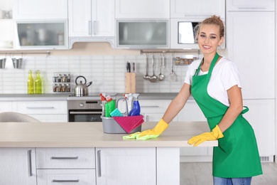 Woman cleaning table with rag in kitchen