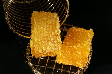 Photo of Natural honeycombs with tasty honey on black background