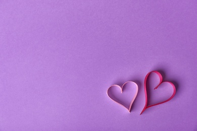 Photo of Hearts made of ribbons and space for text on color background, top view