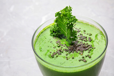 Photo of Tasty kale smoothie with chia seeds on light background, closeup