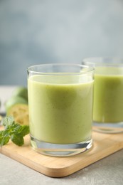 Fresh feijoa smoothie in glass on wooden board, closeup
