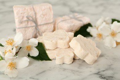 Photo of Beautiful jasmine flowers and soap bars on white marble table