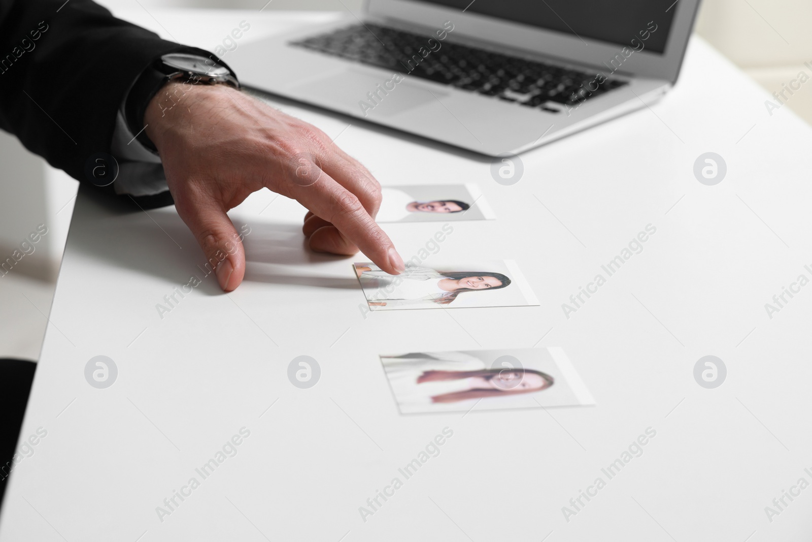 Photo of Human resources manager choosing employee among different applicants at table, closeup