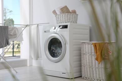 Laundry room interior with washing machine near wall