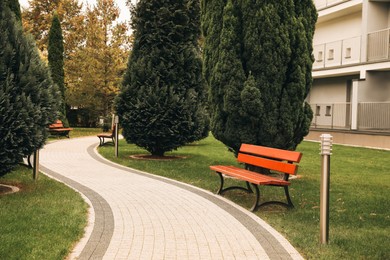 Photo of Winding pathway with beautiful bushes and benches in park
