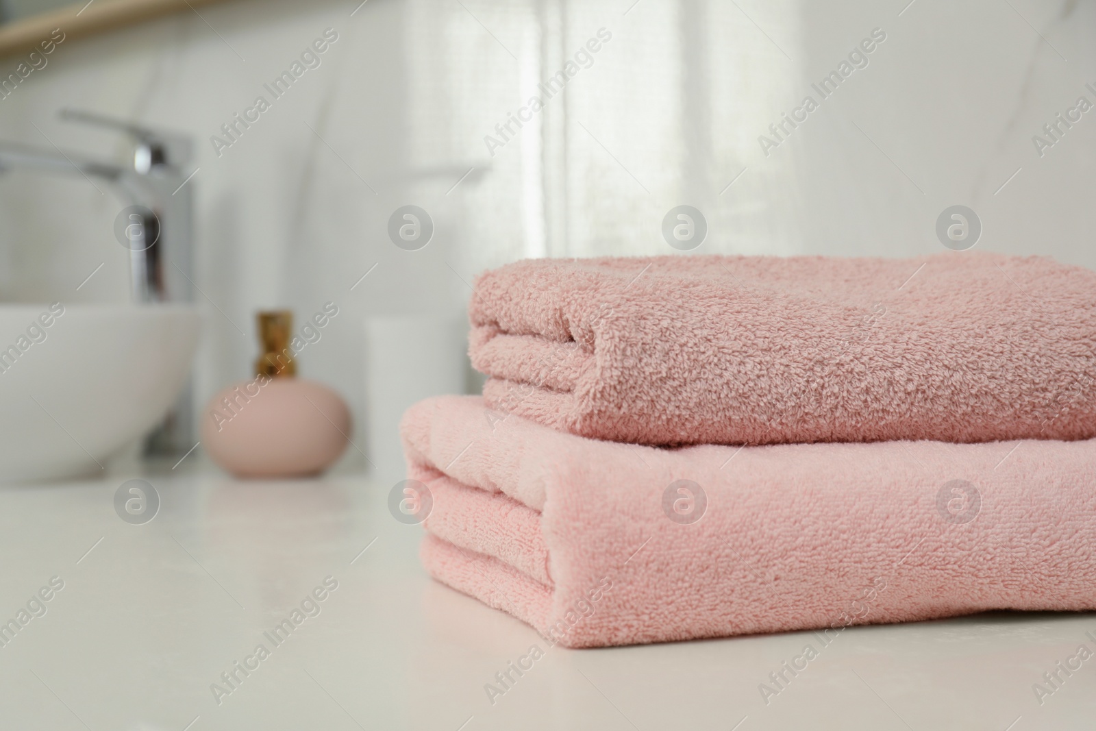 Photo of Stack of clean towels on bathroom countertop