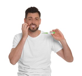 Man with rash holding thermometer on white background. Monkeypox virus diagnosis