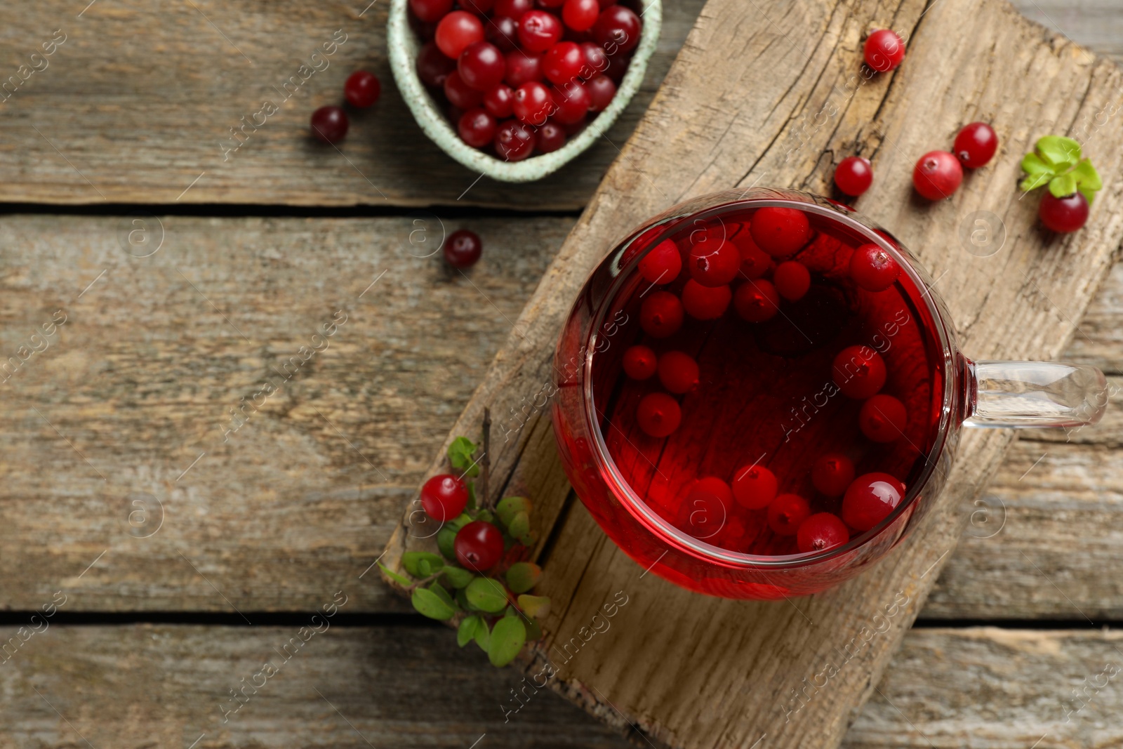 Photo of Delicious cranberry tea and berries on wooden table, flat lay. Space for text