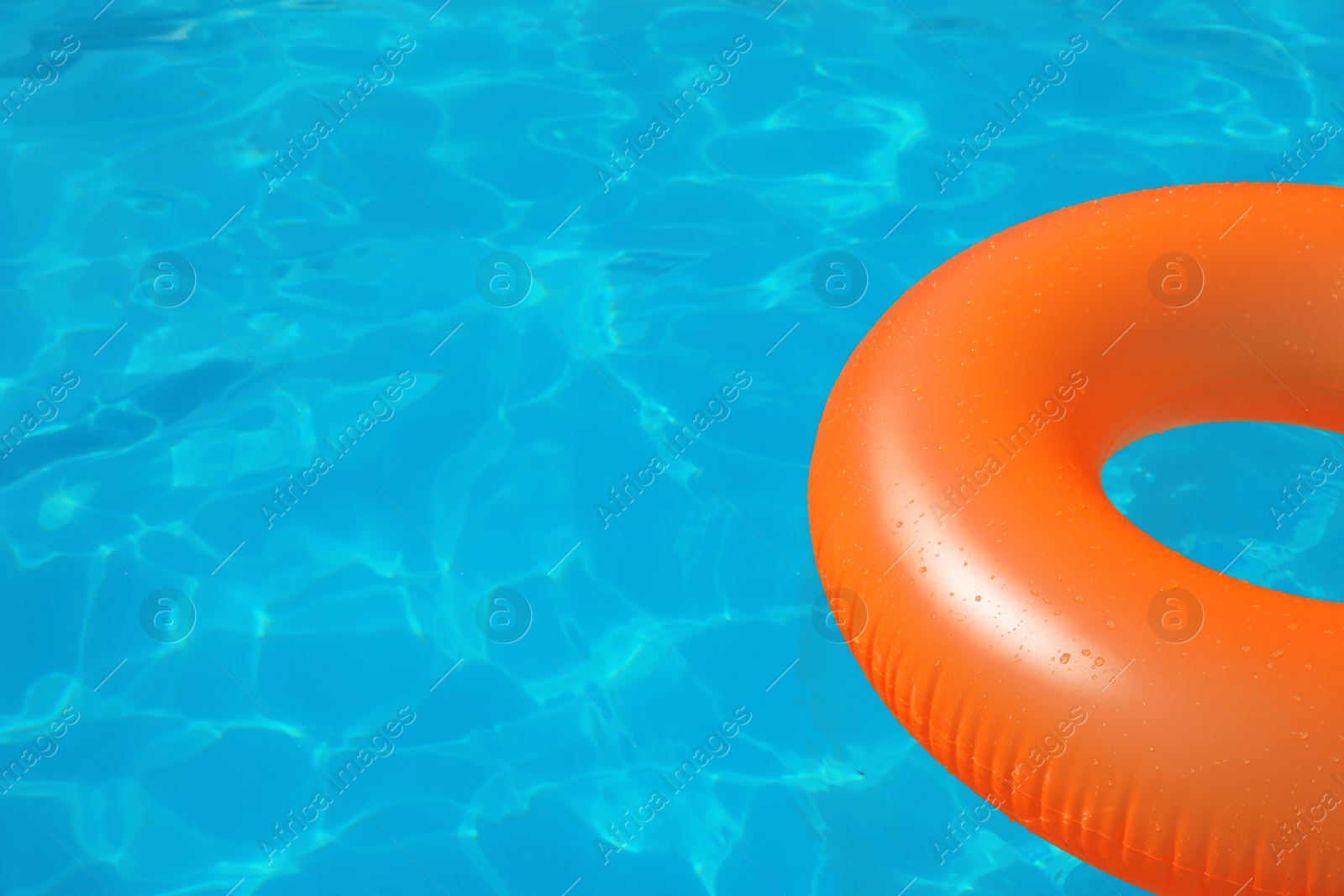 Photo of Inflatable ring floating in swimming pool on sunny day. Space for text