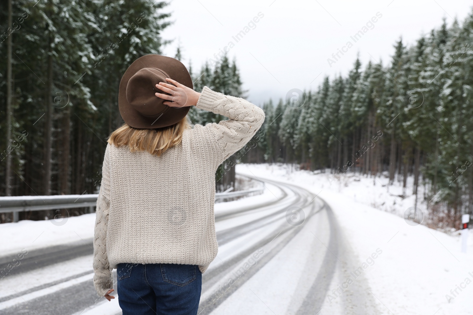 Photo of Young woman walking near snowy forest. Winter vacation