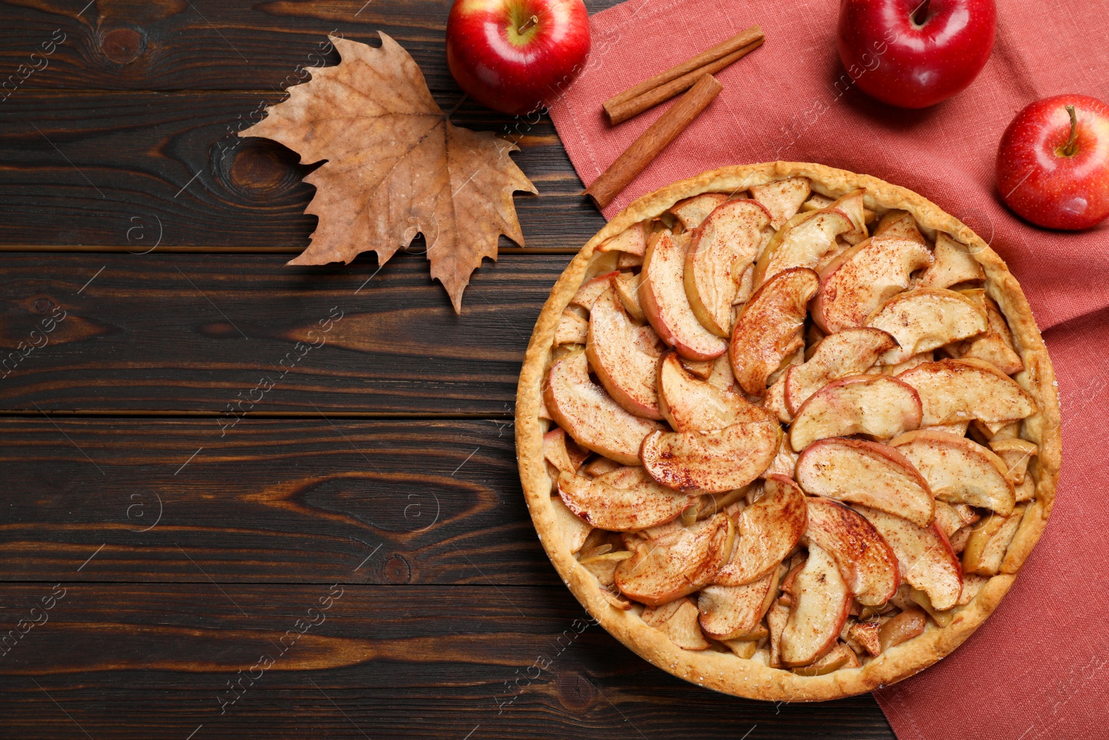 Photo of Delicious apple pie, fresh fruits and cinnamon on wooden table, flat lay. Space for text