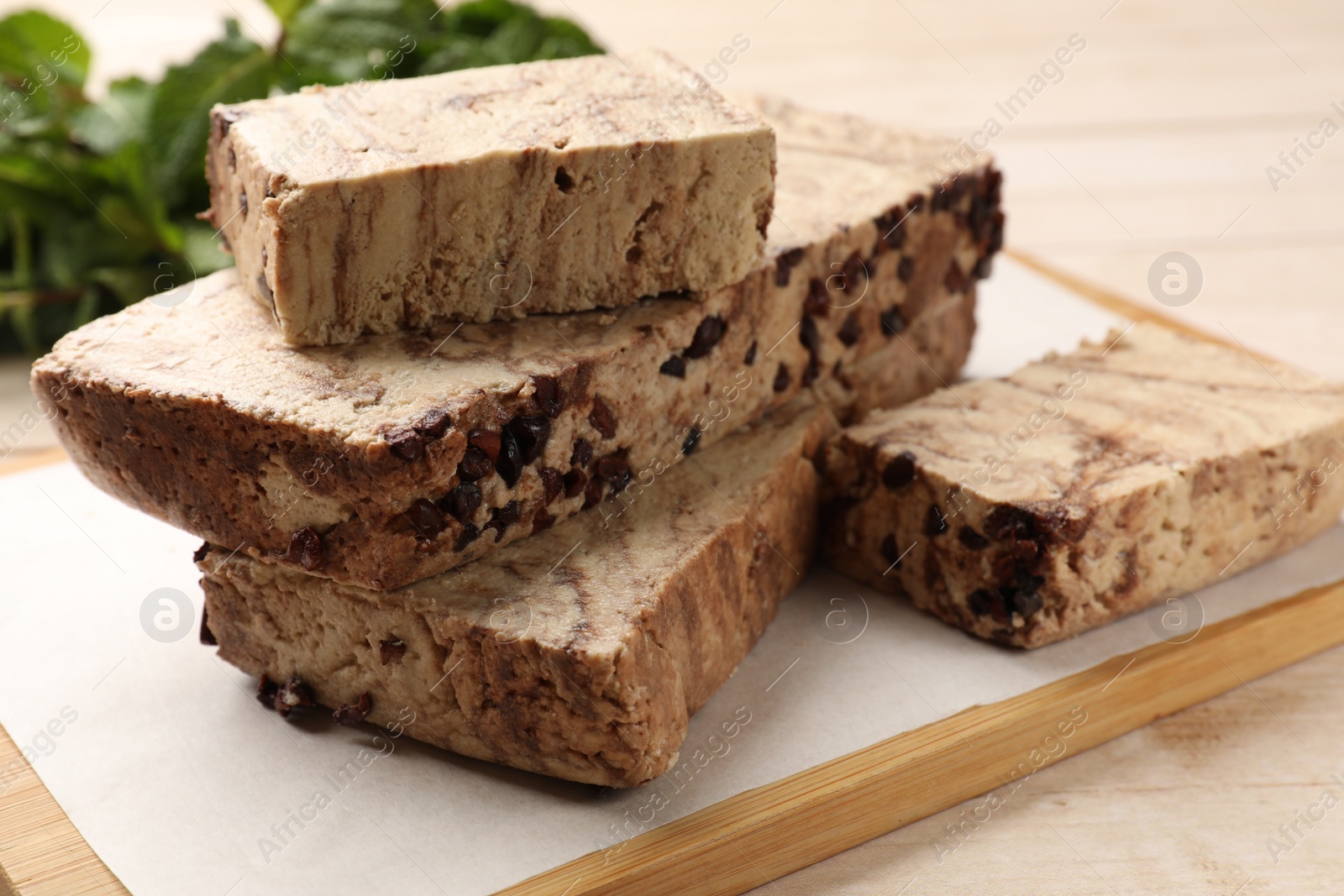 Photo of Pieces of tasty chocolate halva on table, closeup