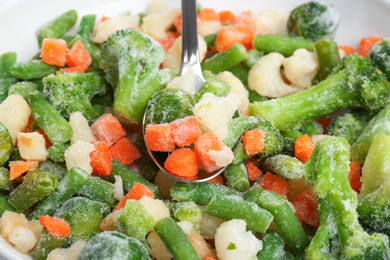 Mix of frozen vegetables and spoon, closeup