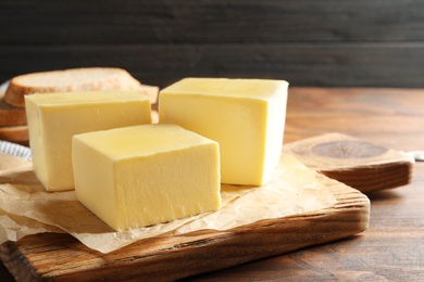 Photo of Wooden board with fresh butter on table. Space for text