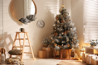 Photo of Beautiful decorated Christmas tree and gift boxes in festive room interior