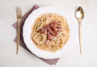 Photo of Delicious Carbonara pasta served on white wooden table, flat lay