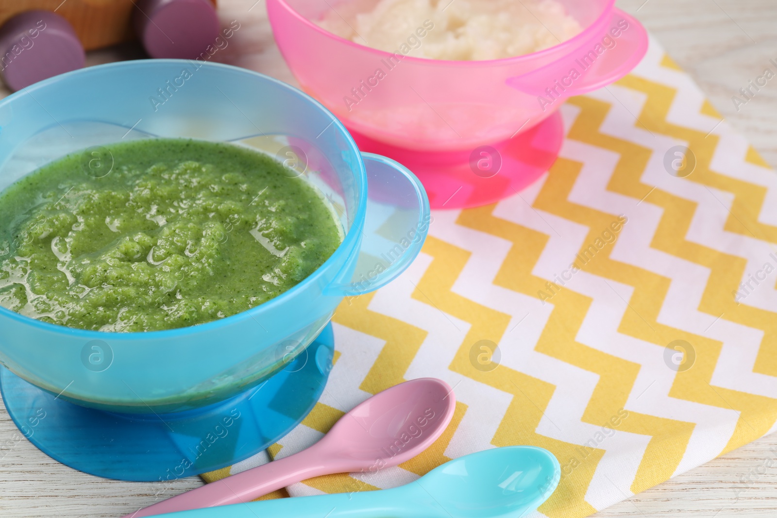 Photo of Healthy baby food. Different tasty puree in bowls on white wooden table