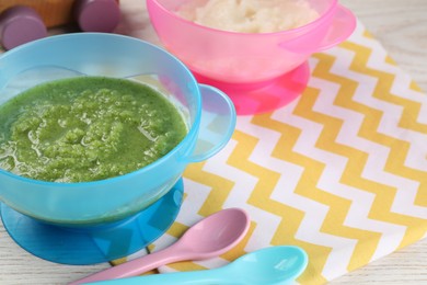Photo of Healthy baby food. Different tasty puree in bowls on white wooden table