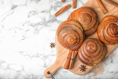 Photo of Flat lay composition with freshly baked cinnamon rolls and space for text on marble background