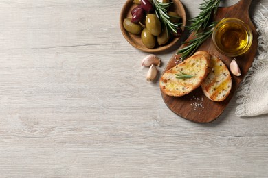 Photo of Tasty bruschettas with oil on white wooden table, flat lay. Space for text