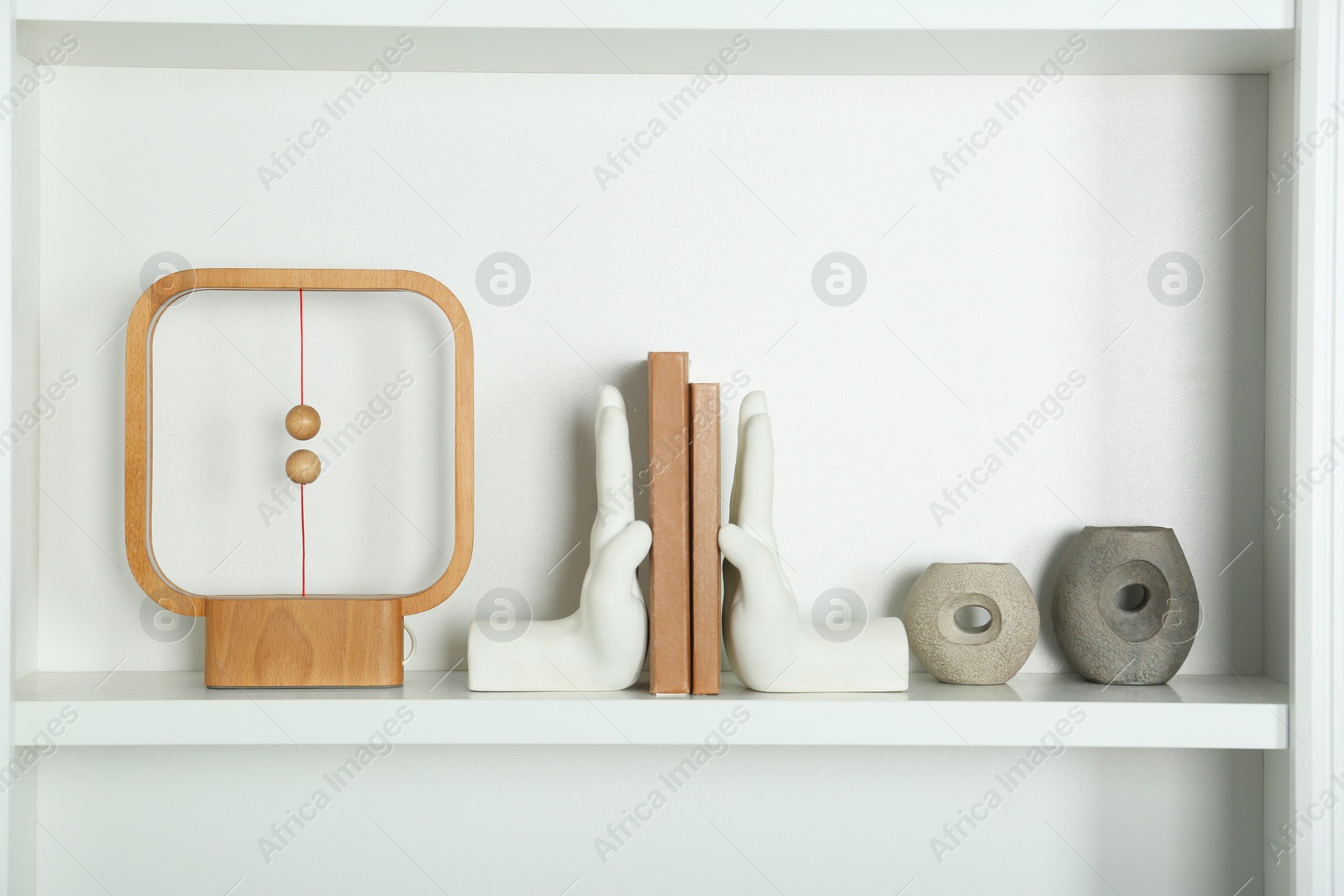 Photo of White shelf with books and different decor indoors. Interior design