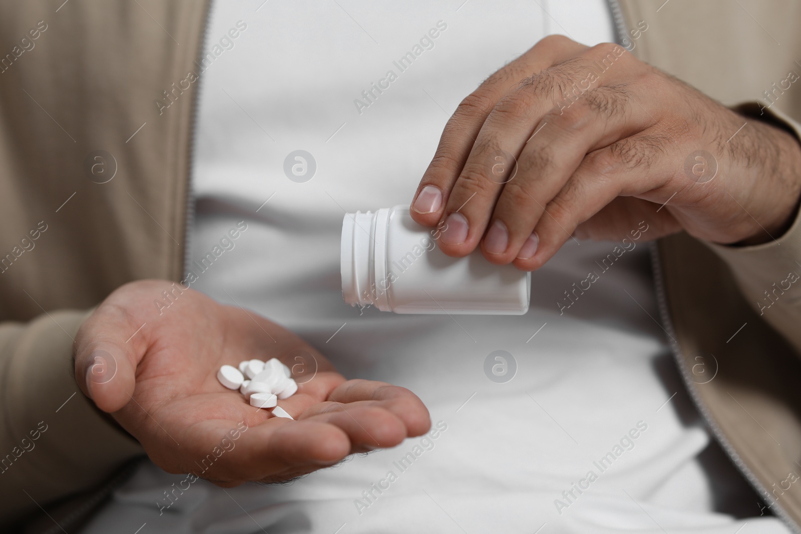Photo of Man pouring antidepressants from bottle onto hand, closeup view