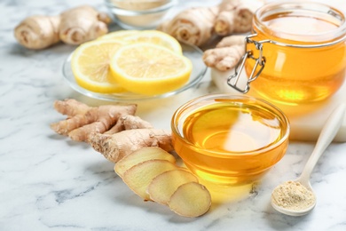 Photo of Honey, ginger and lemon on white table. Natural cold remedies