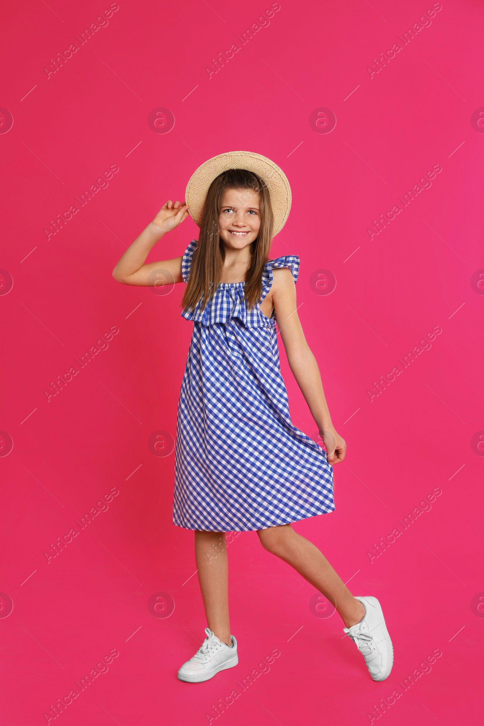 Photo of Full length portrait of preteen girl in hat on pink background