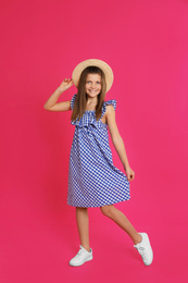 Photo of Full length portrait of preteen girl in hat on pink background