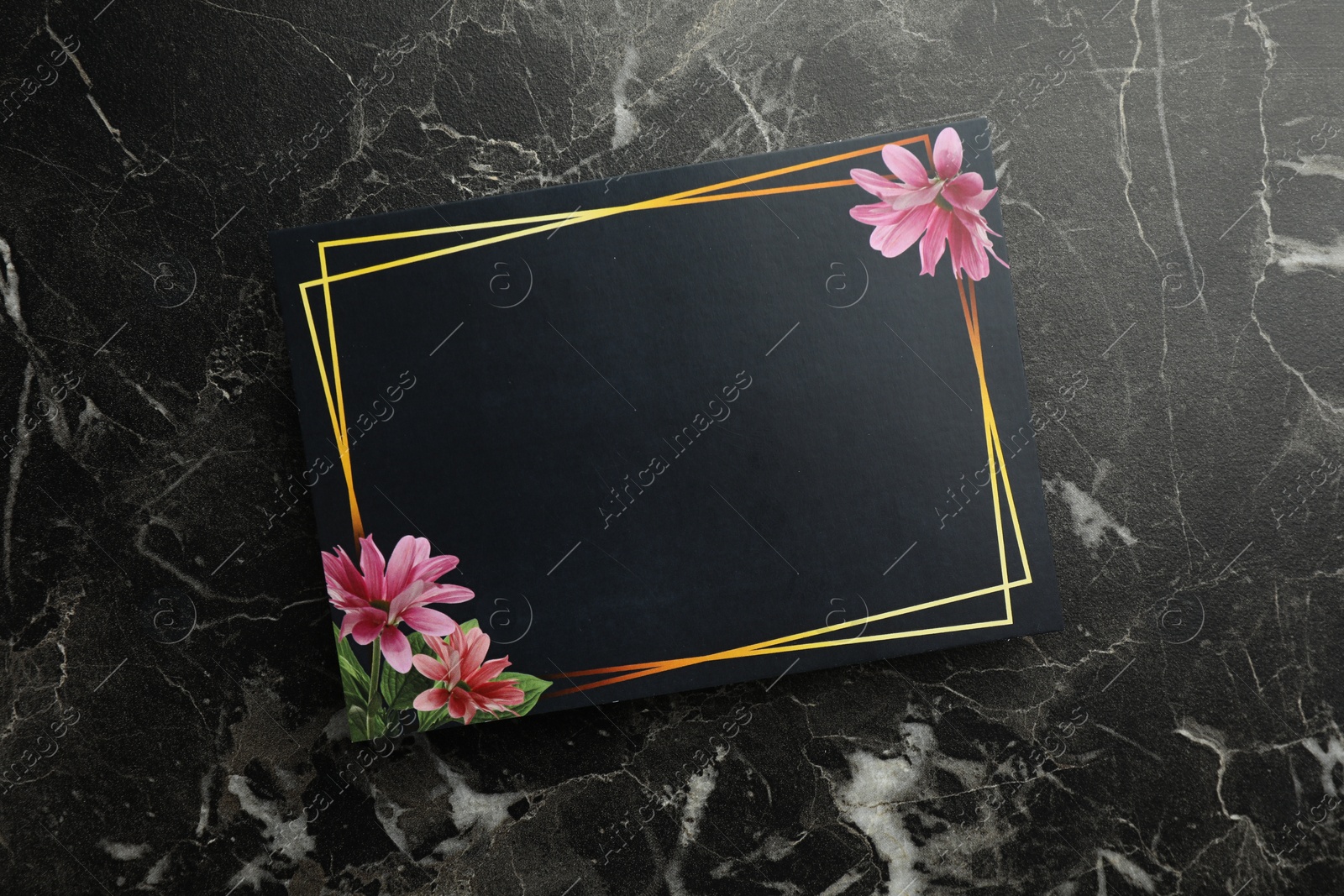 Photo of Blank invitation card on black marble background, top view. Space for text