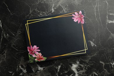 Blank invitation card on black marble background, top view. Space for text