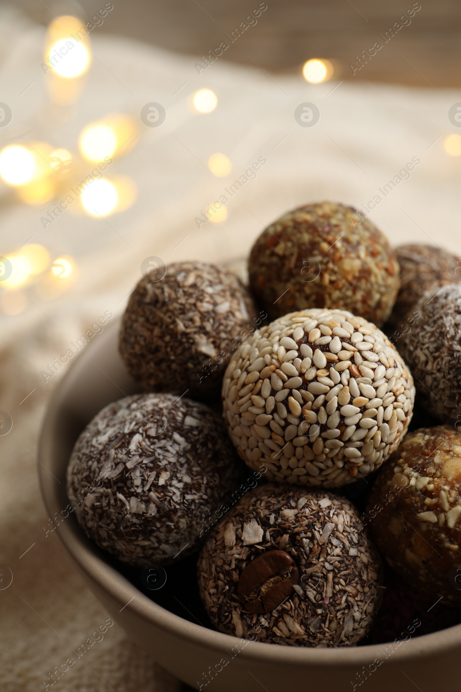 Photo of Different delicious vegan candy balls in bowl, closeup