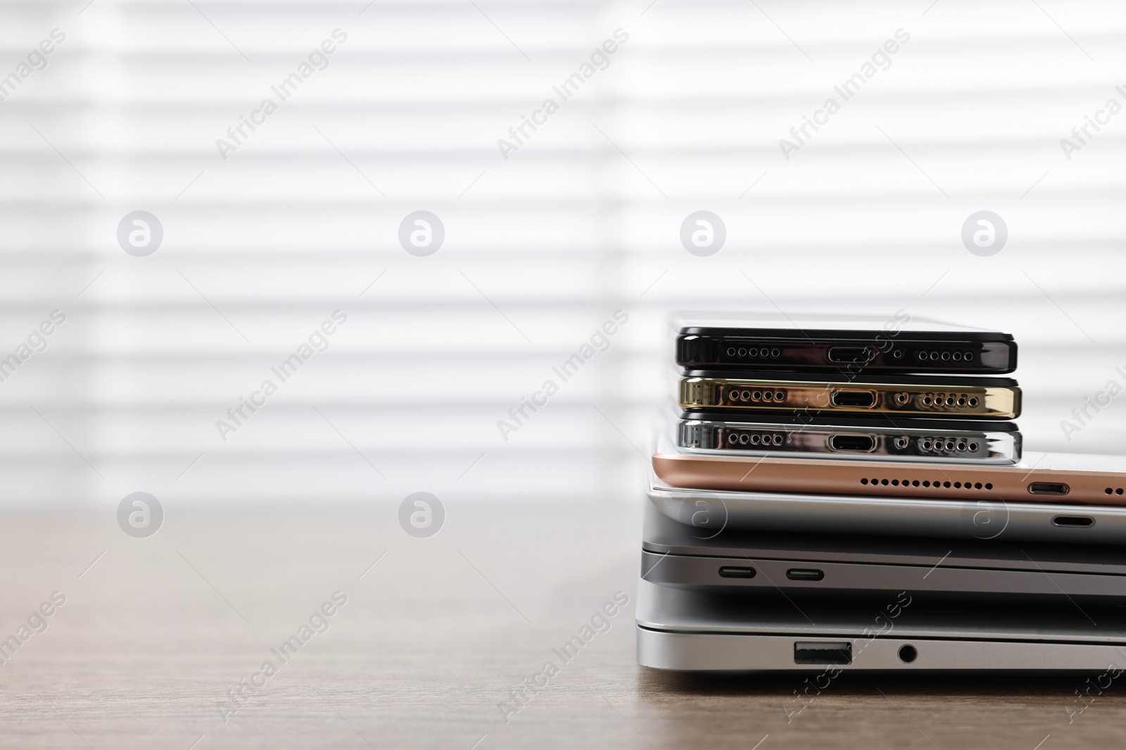 Photo of Many different modern gadgets on wooden table indoors. Space for text