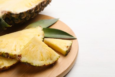 Slices of ripe juicy pineapple on white wooden table, closeup. Space for text