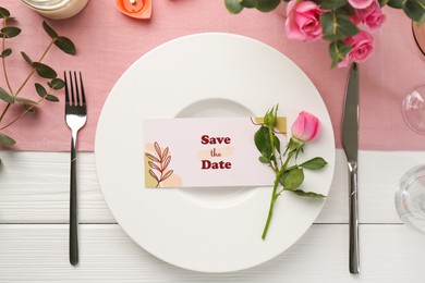 Photo of Romantic place setting with flowers and candles on white wooden table, flat lay