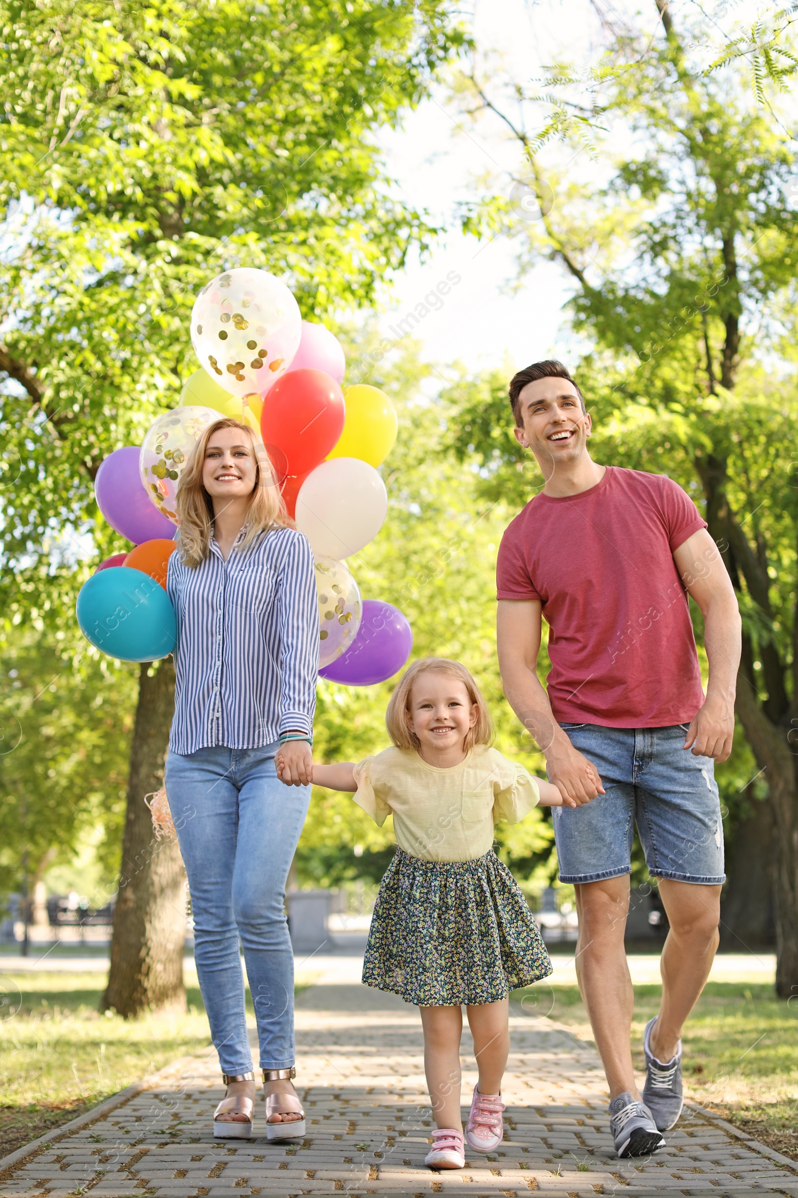 Photo of Happy family with colorful balloons outdoors on sunny day