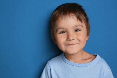 Photo of Portrait of cute little boy on blue background