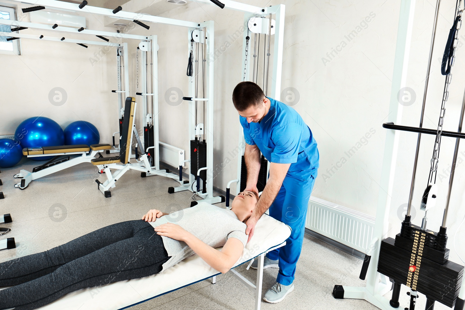 Photo of Physiotherapist working with patient in rehabilitation center