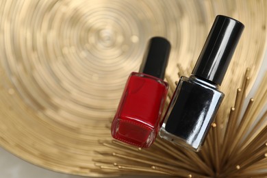 Stylish presentation of bright nail polishes in bottles on golden textured surface, top view. Space for text