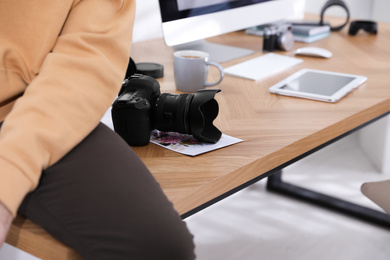 Photo of Professional photographer working in office, focus on camera