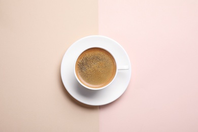 Photo of Cup of aromatic coffee on color background, top view