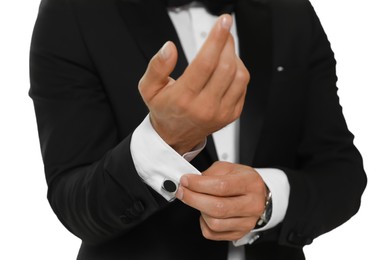 Photo of Stylish man putting on cufflink against white background, closeup