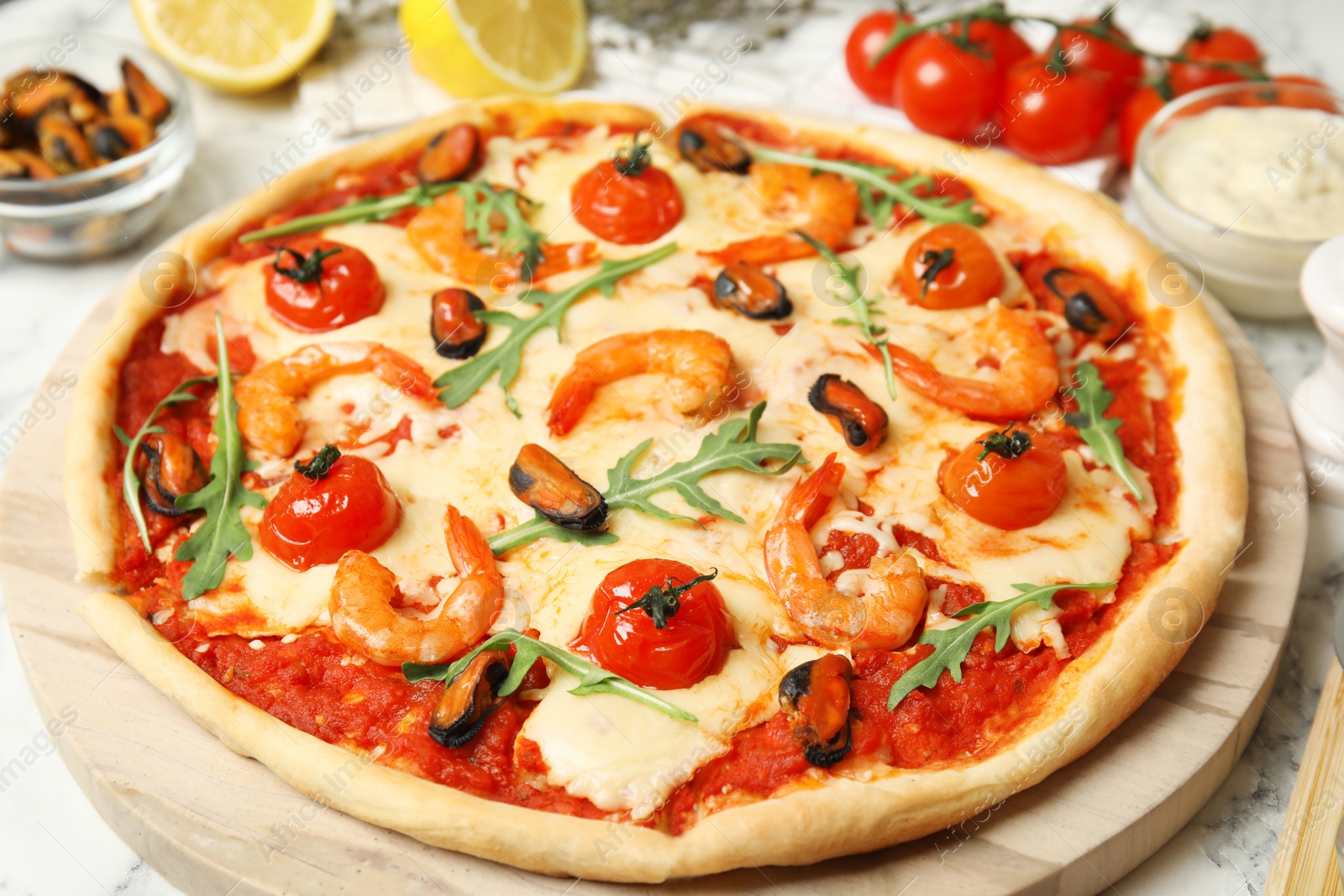 Photo of Delicious seafood pizza on wooden board, closeup